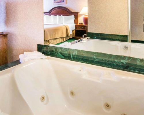 a bath tub in a hotel room with a bed at Quality Inn & Suites Next to the Casino in Ceresco