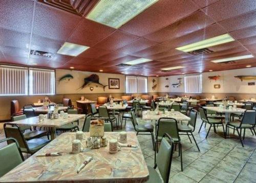 a restaurant with tables and chairs in a room at Rodeway Inn in Muskegon Heights