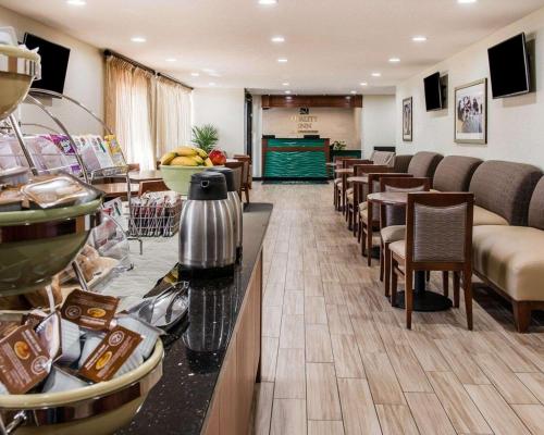 hol ze stołami i krzesłami oraz kawiarnią w obiekcie Quality Inn & Suites Warren - Detroit w mieście Warren