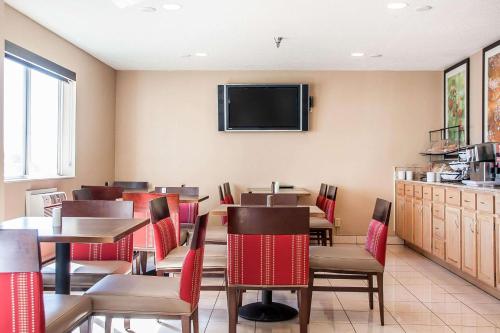 a restaurant with tables and chairs and a flat screen tv at Comfort Inn Fergus Falls in Fergus Falls