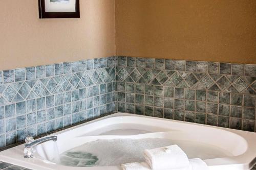a bath tub in a bathroom with blue tiles at Comfort Inn Fergus Falls in Fergus Falls