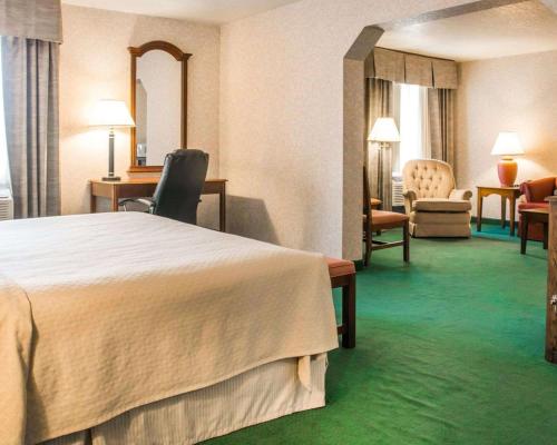 a hotel room with a large bed and chairs at Quality Inn & Suites Next to the Casino in Ceresco