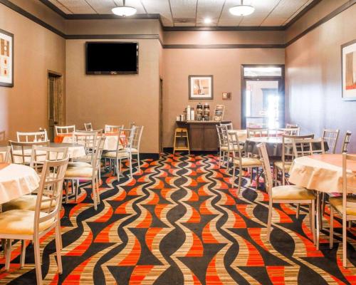 a room with tables and chairs and a flat screen tv at Quality Inn & Suites Next to the Casino in Ceresco