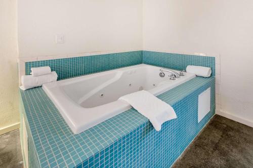 a bathroom with a bath tub with blue tile at Trumbull and Porter - Detroit Downtown in Detroit