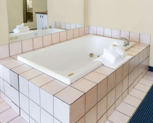 a bath tub with towels sitting in a bathroom at Quality Inn Lakeville North in Lakeville
