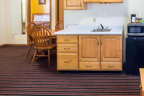 a kitchen with a sink and a table and chairs at Rodeway Inn & Suites Austin in Austin