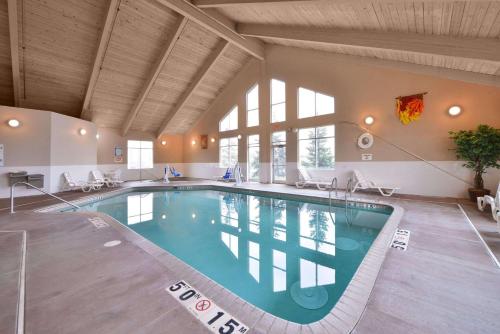 a large swimming pool in a large room with windows at Comfort Inn in Albert Lea