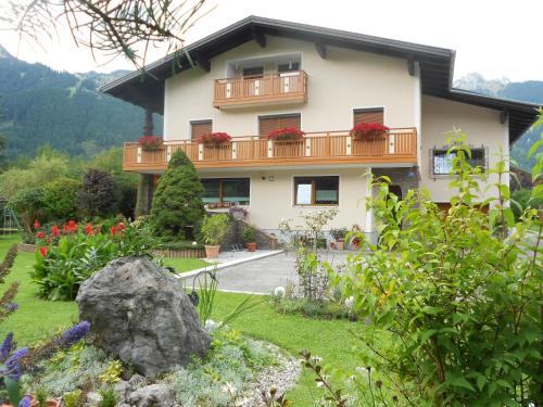 a house with a balcony and flowers in the yard at Ferienwohnung Schreieck Maria in Hofen