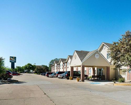 a row of houses with cars parked in a parking lot at Quality Inn near Northtown Mall & National Sports Center in Coon Rapids