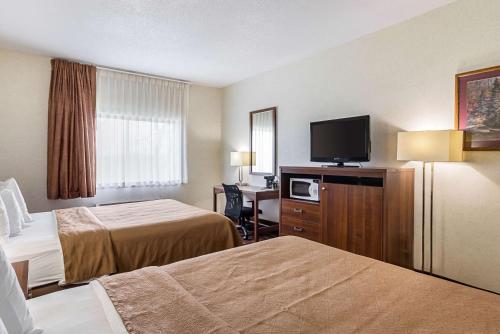 a hotel room with two beds and a flat screen tv at Econo Lodge Luverne I-90 in Luverne