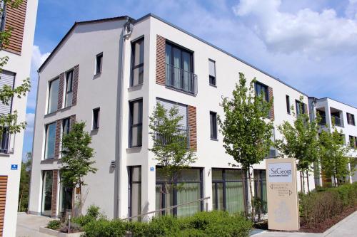 a white building with a sign in front of it at Hotel St Georg - Regensburg in Regensburg