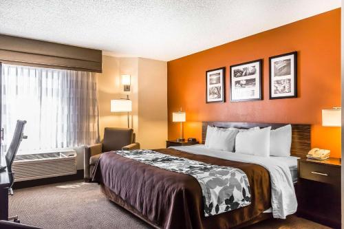 a hotel room with a bed, chair, and nightstand at Sleep Inn Springfield South I60 near Medical District in Springfield