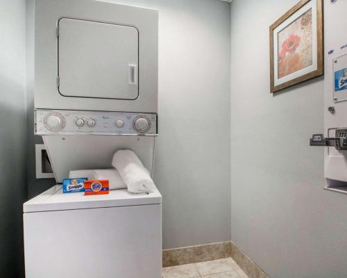 y baño con lavadora, secadora y espejo. en Quality Inn South Springfield, en Springfield