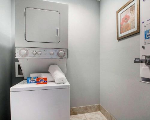a bathroom with a washer and dryer with a mirror at Quality Inn South Springfield in Springfield