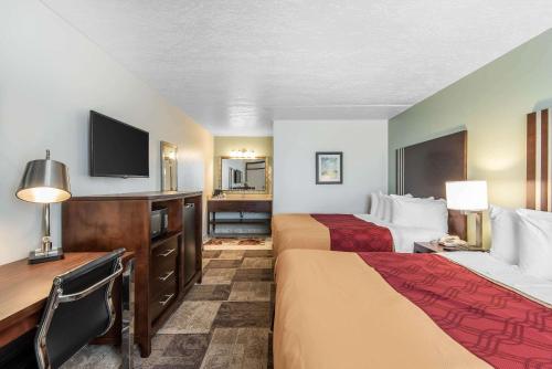 a hotel room with two beds and a flat screen tv at Econo Lodge Oak Grove in Oak Grove