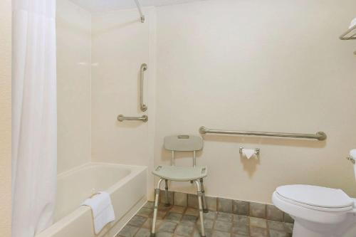 a bathroom with a toilet and a tub and a stool at Quality Inn Charleston I-57 in Charleston