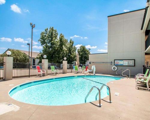 a swimming pool with chairs and a building at Quality Inn US65 & E Battlefield Rd Springfield in Springfield