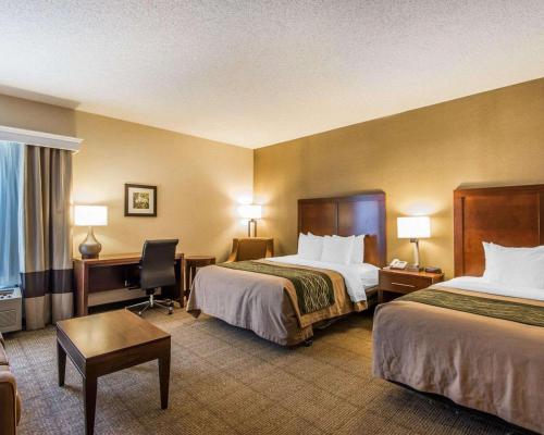 a hotel room with two beds and a desk at Quality Inn Cameron in Cameron