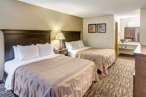 a hotel room with two beds and a kitchen at Quality Inn West in Branson