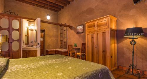 um quarto com uma cama e um candeeiro num quarto em Hotel Refugio del Angel em Pátzcuaro