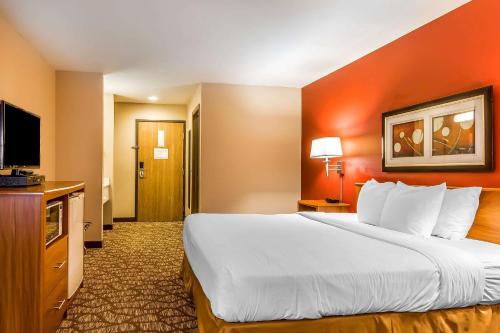 a hotel room with a large bed and a flat screen tv at Quality Inn & Suites Chesterfield Village in Springfield