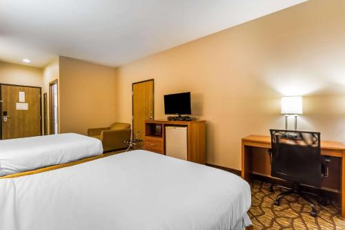 a hotel room with two beds and a desk with a television at Quality Inn & Suites Chesterfield Village in Springfield