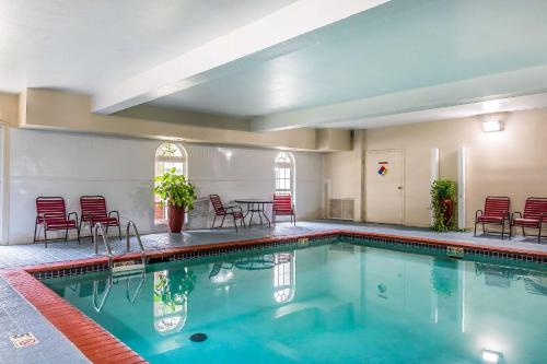 a pool with chairs and a table in a building at Quality Inn & Suites Chesterfield Village in Springfield