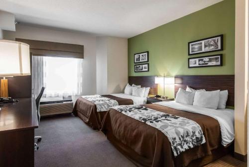 een hotelkamer met 2 bedden en een raam bij Sleep Inn in St. Charles