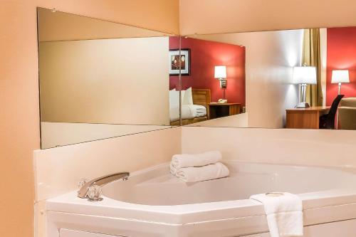 y baño con bañera y espejo grande. en Quality Inn & Suites Chesterfield Village, en Springfield