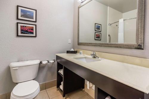 a bathroom with a toilet and a sink with a mirror at Comfort Suites St Charles-St Louis in St. Charles