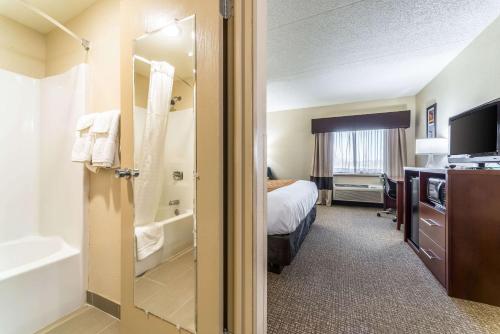 a hotel room with a bathroom with a bed and a tub at Comfort Inn Festus-St Louis South in Festus