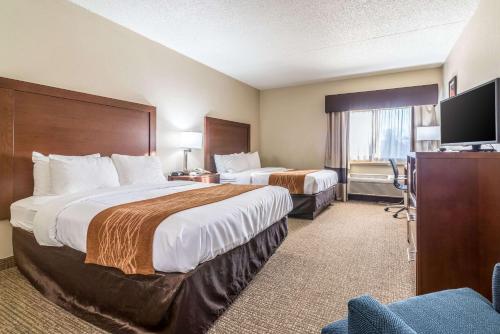 a hotel room with two beds and a flat screen tv at Comfort Inn Festus-St Louis South in Festus