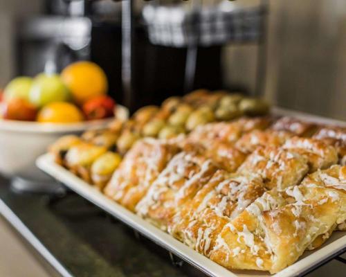 una fila di pasticcini su un bancone con una ciotola di frutta di Comfort Inn Sullivan a Sullivan