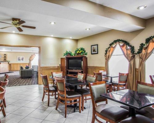 a dining room with tables and chairs and a tv at Quality Inn Belton - Kansas City South in Belton