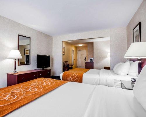 a hotel room with two beds and a flat screen tv at Comfort Suites Independence - Kansas City in Independence