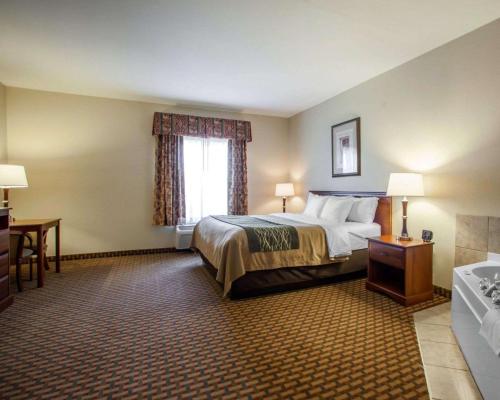 una stanza d'albergo con un letto, una scrivania e una finestra di Comfort Inn & Suites Harrisonville a Harrisonville