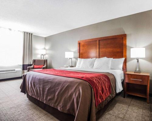 a hotel room with a large bed and a chair at Comfort Inn & Suites Moberly in Moberly