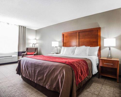 MoberlyComfort Inn & Suites Moberly的配有一张大床和一把椅子的酒店房间
