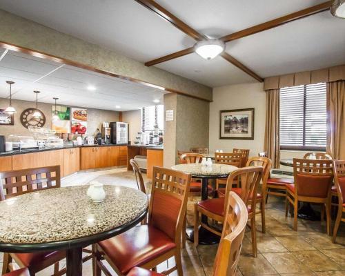 a restaurant with tables and chairs and a kitchen at Quality Inn & Suites North in Springfield