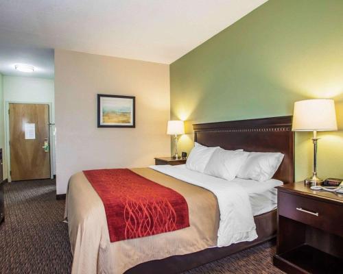 a hotel room with a large bed with a red blanket at Quality Inn Belton - Kansas City South in Belton