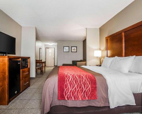 a hotel room with a large bed and a flat screen tv at Comfort Inn & Suites Moberly in Moberly