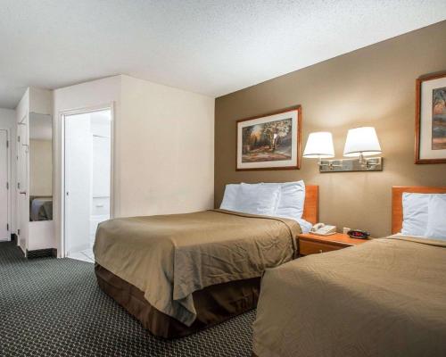 a hotel room with two beds and a phone at Suburban Studios Columbia - Hwy 63 & I-70 in Columbia