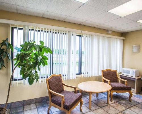 a waiting room with a table and chairs and a microwave at Relax Inn Saint Charles in St. Charles