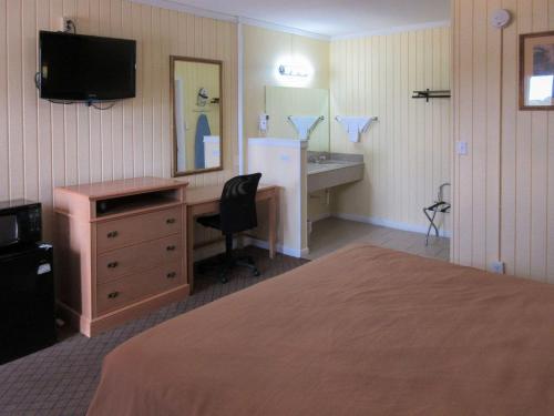 a hotel room with a bed and a desk and a television at Rodeway Inn Kansas City Downtown Area in Kansas City