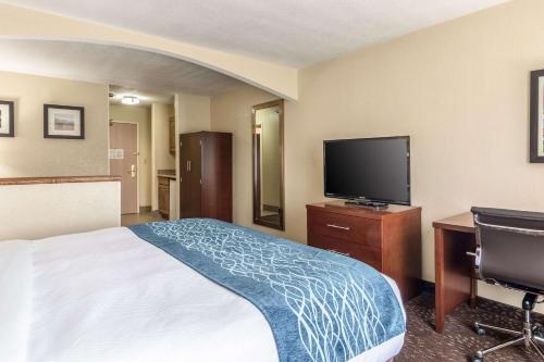 a hotel room with a bed and a flat screen tv at Comfort Inn & Suites - Hannibal in Hannibal