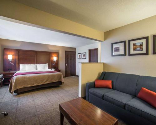 une chambre d'hôtel avec un lit et un canapé dans l'établissement Quality Inn & Suites Boonville - Columbia, à Boonville