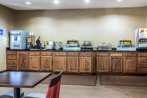 a kitchen with wooden cabinets and a table and a counter top at Comfort Inn & Suites - Hannibal in Hannibal