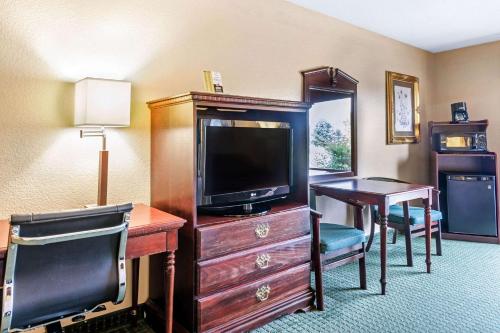 a hotel room with a desk and a tv and a deskablish at Quality Inn & Suites in Carthage