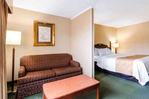 a hotel room with a couch and a bed at Quality Inn & Suites in Carthage