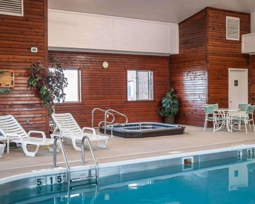 a swimming pool with chairs and a table and a swimming pool at Quality Inn & Suites Boonville - Columbia in Boonville